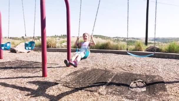 Mała Dziewczynka Bawiąca Się Huśtawkach Placu Zabaw Przedmieściach — Wideo stockowe