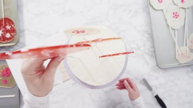 Süslenmek için uzun beyaz yuvarlak pastanın içine kar taneli büyük lolipoplar yerleştiriyoruz..