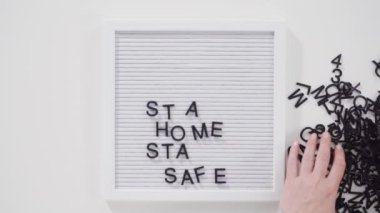 Evde Kal ve COVID-19 tabelasında ev yapımı yüz maskesi var..