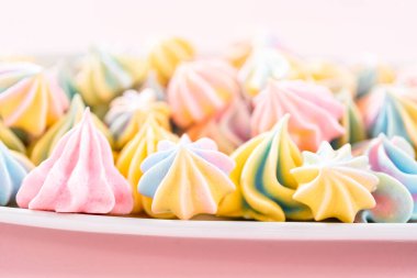 Beyaz servis tabağında çok renkli tek boynuzlu at kurabiyeleri..