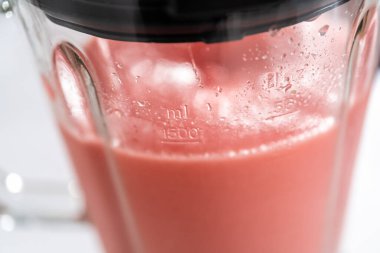 Donmuş karpuz margaritası hazırlamak için mutfak blendırında karışım malzemesi..