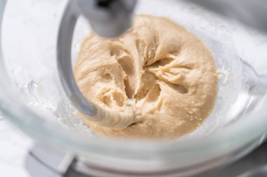 Büyük bir bardaktaki malzemeleri karıştırıyorum. Pizza hamuruyla karıştırıyorum..