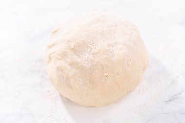 Tarçınlı tatlı pizzası hazırlamak için Fransız merdanesiyle pizza hamuru yuvarlıyorum..