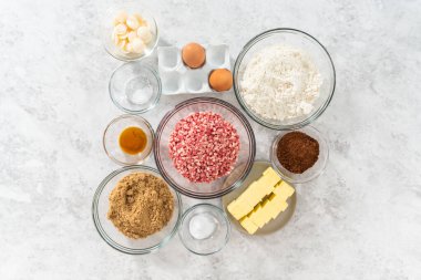 Düz yatıyordu. Çikolatalı kurabiyeleri naneli cipsle karıştırmak için bardaktaki ölçülü malzemeler..