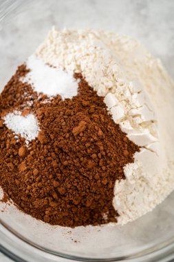 Çikolatalı kurabiyeleri naneli cipsle karıştırmak için büyük bir bardaktaki malzemeleri karıştırıyorum..