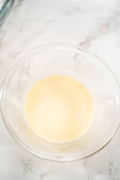玻璃搅拌碗中量出的配料使蛋黄奶油起泡 — 图库照片