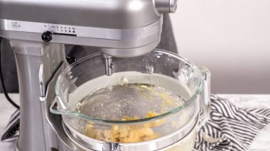 Adım adım. Ev yapımı brioche çörekleri pişirmek için mutfak mikserindeki malzemeleri karıştırıyorum..