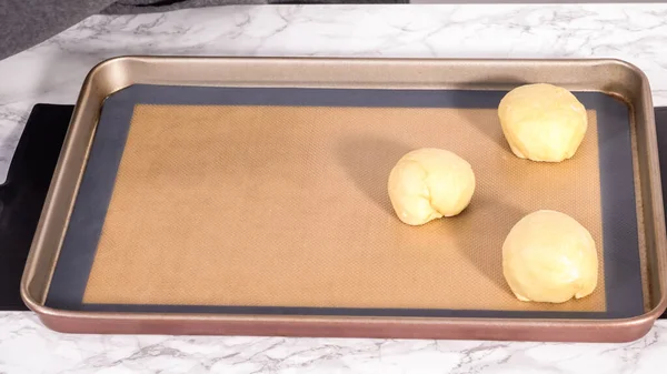 Step by step. Rising brioche dough on a baking sheet with a silicone mat.