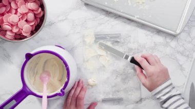 Mermer tezgahın üzerindeki beyaz fondanla kar tanelerini keserek..