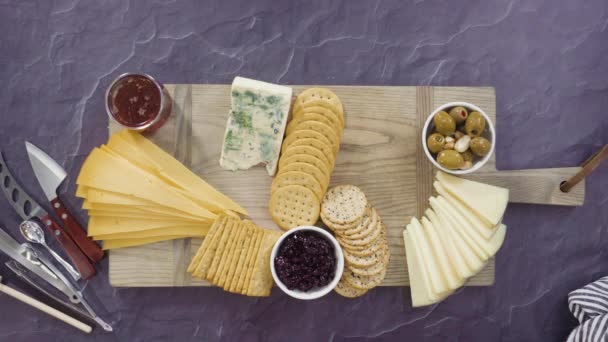 大きなチーズボードのためのボード上のグルメチーズ クラッカー 果物の手配 — ストック動画