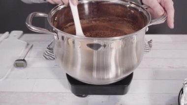 Basit çikolatalı şekerlemeler yapmak için yemek kabındaki malzemeleri karıştırıyorum..