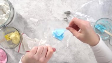 Tek boynuzlu at meringue kurabiyesi pişirmek için metal uçlu boru torbalarına krema karışımı aktarılıyor..