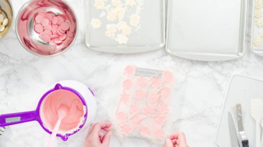 Düz yatıyordu. Adım adım. Erimiş çikolatayı kar taneleri şeklinde plastik bir çikolata kalıbına döküyorum..