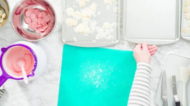 Düz yatıyordu. Adım adım. Fazla çikolatayı, kar taneleri şeklindeki çikolatalardan küçük bir mutfak bıçağıyla budamak..