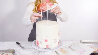 Süslenmek için uzun beyaz yuvarlak pastanın içine kar taneli büyük lolipoplar yerleştiriyoruz..