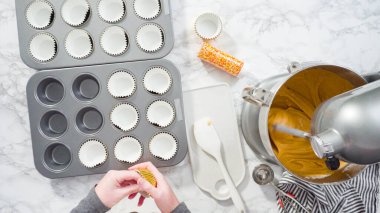 Düz yatıyordu. Balkabağı aromalı kek hamuru. Hamur hamuru kepçesiyle kapkek tepsisine dolgu malzemesi..