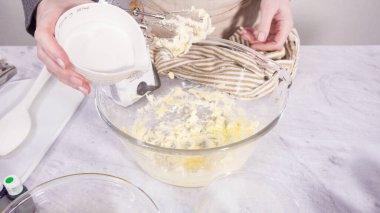 Adım adım. Vanilyalı Mardi Gras kekleri pişirmek için karışımı elektrikli mikserle karıştırıyorum..