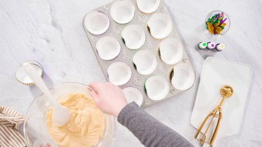 Düz yatıyordu. Adım adım. Vanilyalı Mardi Gras keki pişirmek için kek hamurunu folyoya batırıyorum..