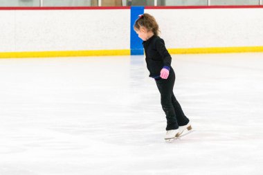 Küçük patenci sabah artistik patinaj antrenmanında elementlerini çalışıyor..