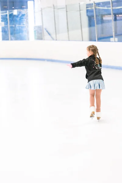 Kleines Mädchen Übt Eiskunstlauf Auf Einer Überdachten Eisbahn — Stockfoto