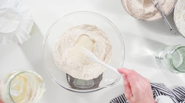 Düz yatıyordu. Tarçınlı rulo pişirmek için cam bir kasenin içindekileri ölçüyorum..