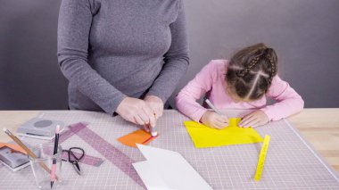 İnşaat kağıdından el yapımı Babalar Günü kartı yapan küçük bir kız..