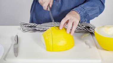 Adım adım. Beyaz kesme tahtasında kaygan altın çiğ taneli kavun.