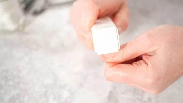 Woman finishing her manicure at home with simple manicure tools. Buffering nails with a nail buffer block.
