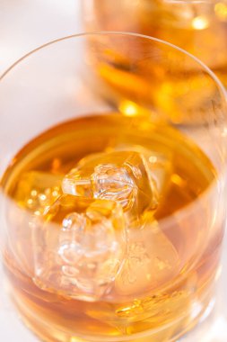 Buzlu viski, viski bardağında, beyaz mermer yüzeyde..