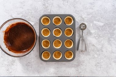 Düz yatıyordu. Folyo kaplarını çikolatalı kek hamuruyla doldurup kek pişirmek..