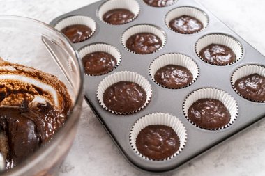 Çikolatalı çilekli kek pişirmek için kek hamurunu kek kaplarının içine atıyoruz..