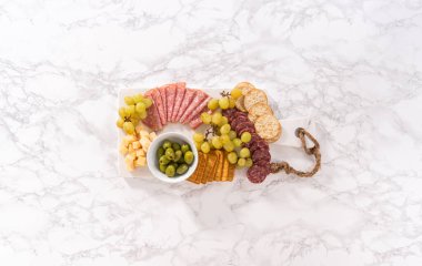 Düz yatıyordu. Peynir, et ve kraker. Mermer yüzeyde aperatif..