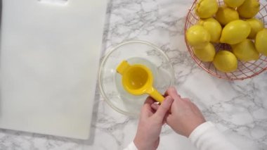 Limonlu kek pişirmek için taze limon sıkmak..