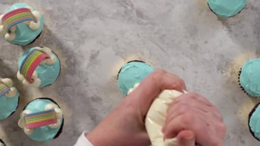 Adım adım. Tek boynuzlu at temalı doğum günü partisi için mavi tereyağlı krema ve gökkuşağıyla süslenmiş çikolatalı kekler..