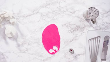 Düz yatıyordu. Adım adım. Mermer tezgahın üstünde pembe fondanla kar tanelerini keserek..