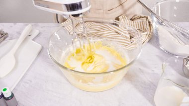 Adım adım. Vanilyalı Mardi Gras kekleri pişirmek için karışımı elektrikli mikserle karıştırıyorum..