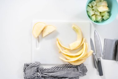 Düz yatıyordu. Beyaz kesme tahtasında kaygan altın çiğ taneli kavun.