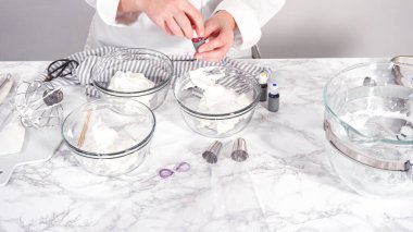 Adım adım. Tek boynuzlu at kurabiyesi pişirmek için besin boyasını kremaya karıştırıyorum..