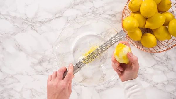 平置きだ 一歩ずつ 新鮮なレモンをガラスの混合ボウルに入れ レモンの束ケーキを準備する — ストック写真