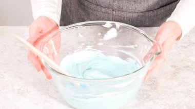 Adım adım. Tereyağlı kremaya mavi gıda boyası karıştırıyorum..