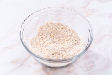 Elmalı yulaflı kurabiye pişirmek için büyük bir bardakta karıştırma malzemesi..