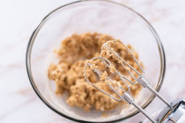 Elmalı yulaflı kurabiye pişirmek için büyük bir bardakta karıştırma malzemesi..