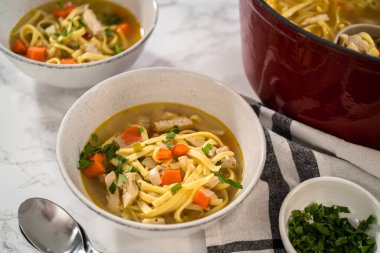 Beyaz seramik çorba kaselerinde kluski şehriyeli tavuk çorbası servis ediyorum..