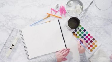 Baker küçük bir kızın doğum günü partisi için doğum günü pastası tasarlıyor..