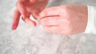 Kadın manikürünü evde basit manikür aletleriyle bitiriyor. Tırnaklarındaki eski ojeleri çıkarıyorum..