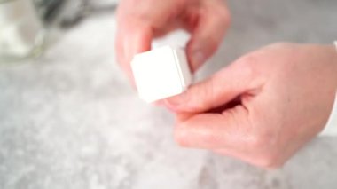 Kadın manikürünü evde basit manikür aletleriyle bitiriyor. Çivi tampon bloğu ile tampon çiviler.