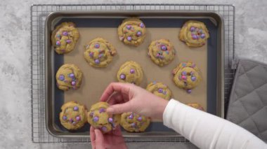 Tek boynuzlu at çikolatalı kurabiyeler ve tezgahta gökkuşağı çikolata parçaları..