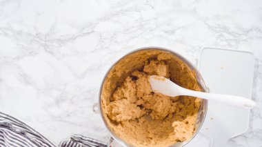 Düz yatıyordu. Adım adım. Fıstık ezmeli kurabiye pişirmek için elektrikli mikserin malzemelerini karıştırıyorum..