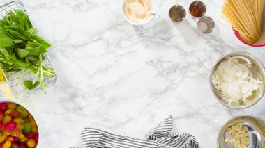 Düz yatıyordu. Adım adım. Tek demlik makarna tarifi yapmak için beyaz bir kesim tahtasıyla sebze kesmek..