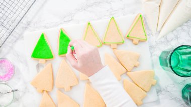 Düz yatıyordu. - Adım adım. Buzlu Noel ağacı şekilli şeker kurabiyeleri ve yeşil kraliyet kreması..